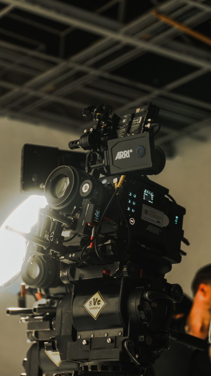 A wide professional video commercial set in India displaying glowing dynamic movie light frames and large cameras